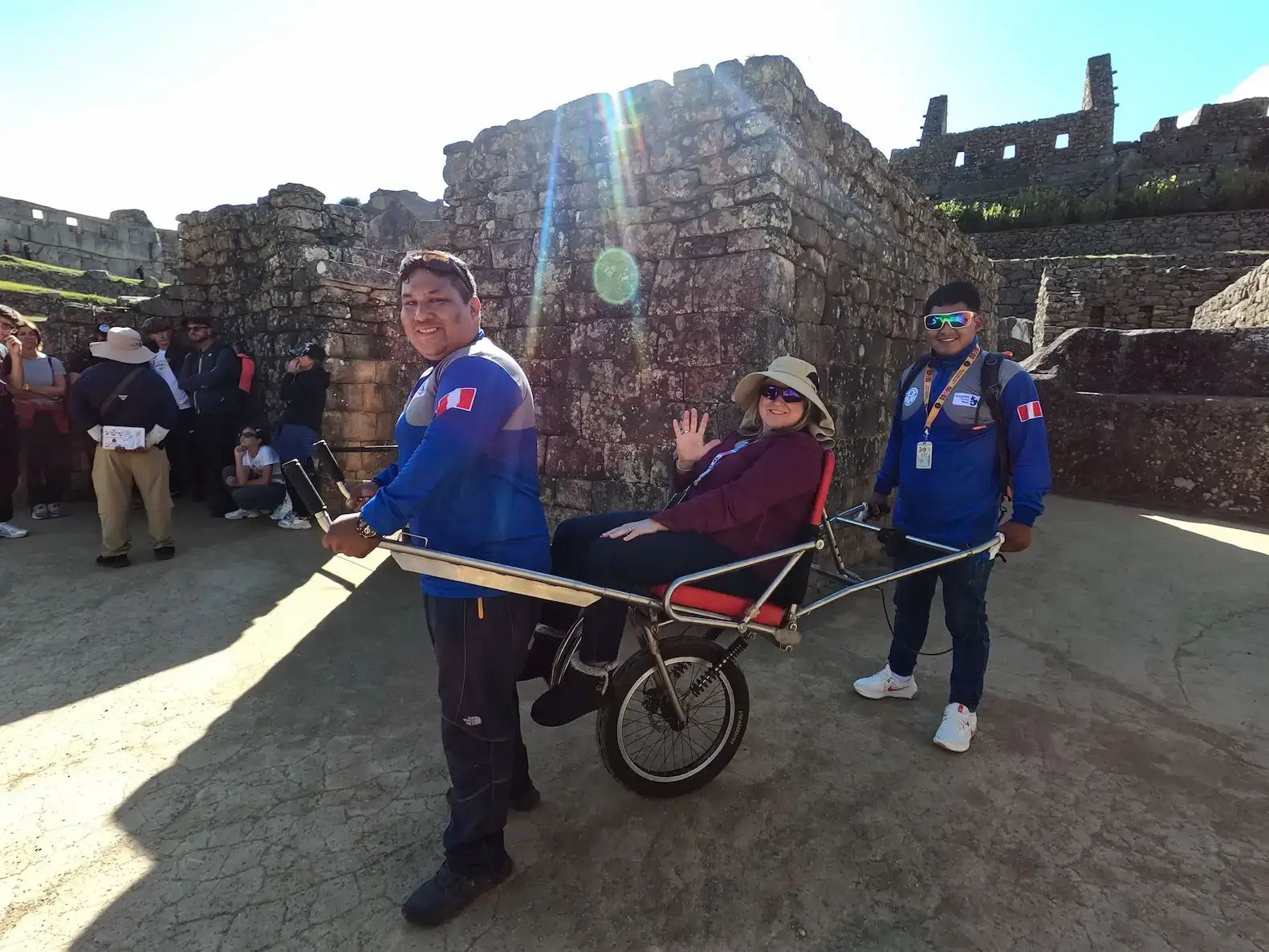 wheelchair traveler carried by Accessible Travel Peru guide inside Machu Picchu ruins Peru accessible tour